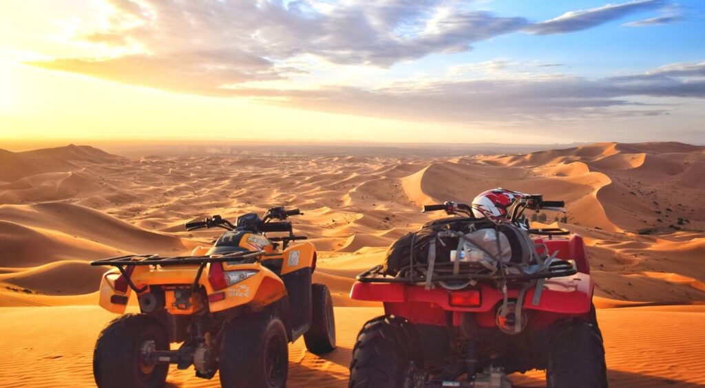 Two quad bikes parked on Merzouga dunes in low evening light